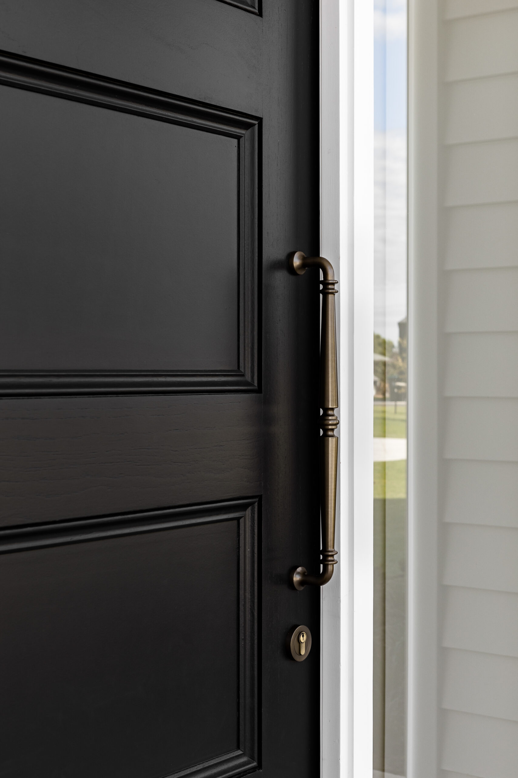 Black front door with Sarlat Pull Handle in signature brass finish
