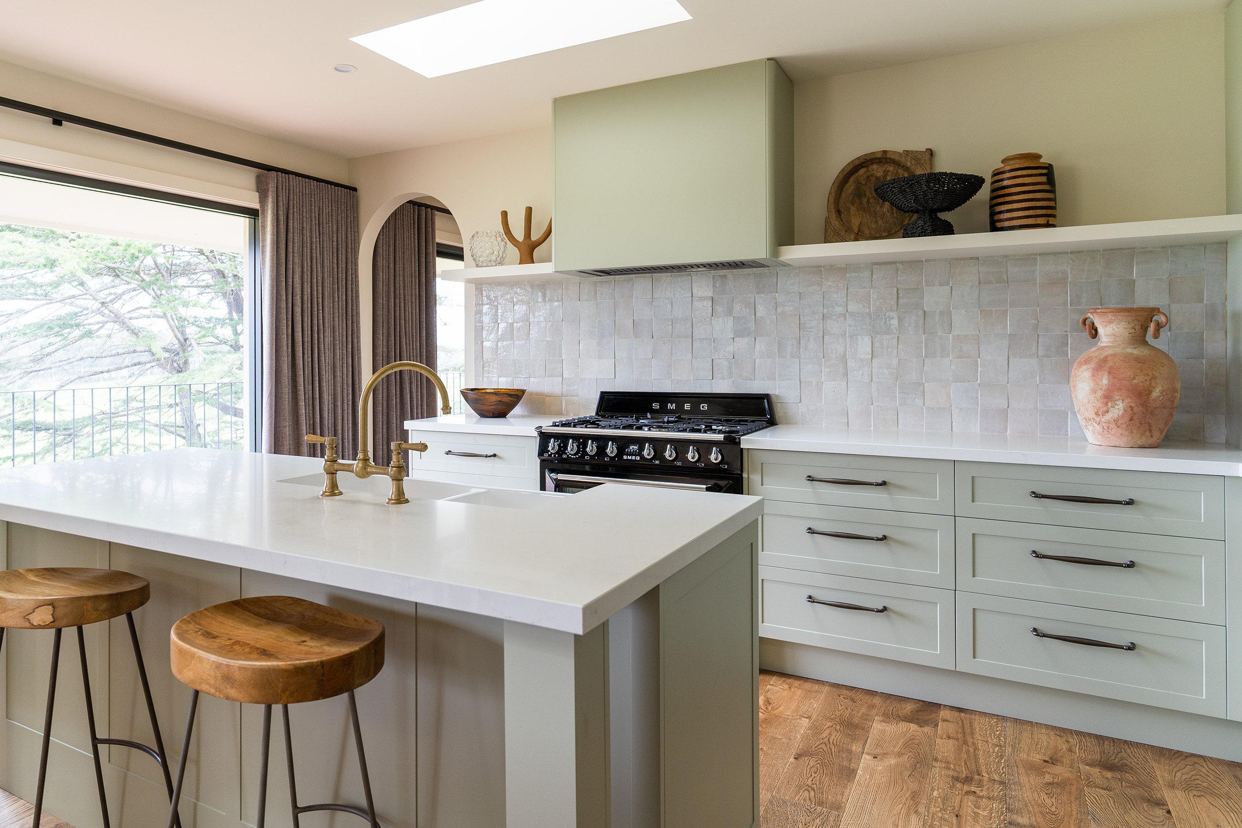 The Villa Meroo Kitchen features green cabinetry and the Sarlat Cabinet Pulls in Signature Brass