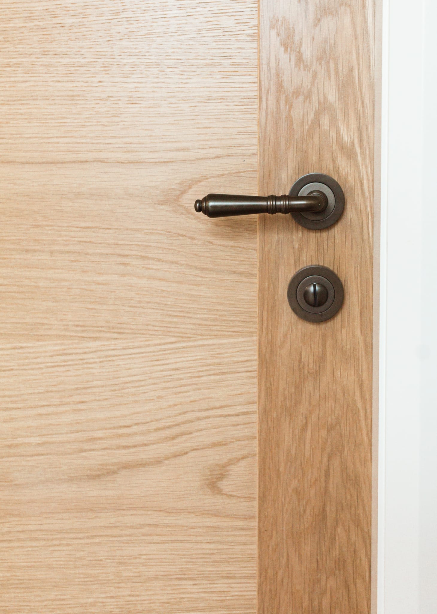 An interior timber door is adorned with the Sarlat Lever and Privacy Turn in Signature Brass.