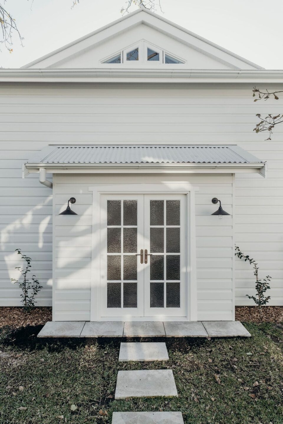 French doors mark the entrance to the home's backyard. Adorned with Sarlat Levers in Signature Brass, the hardware adds a touch of warmth.