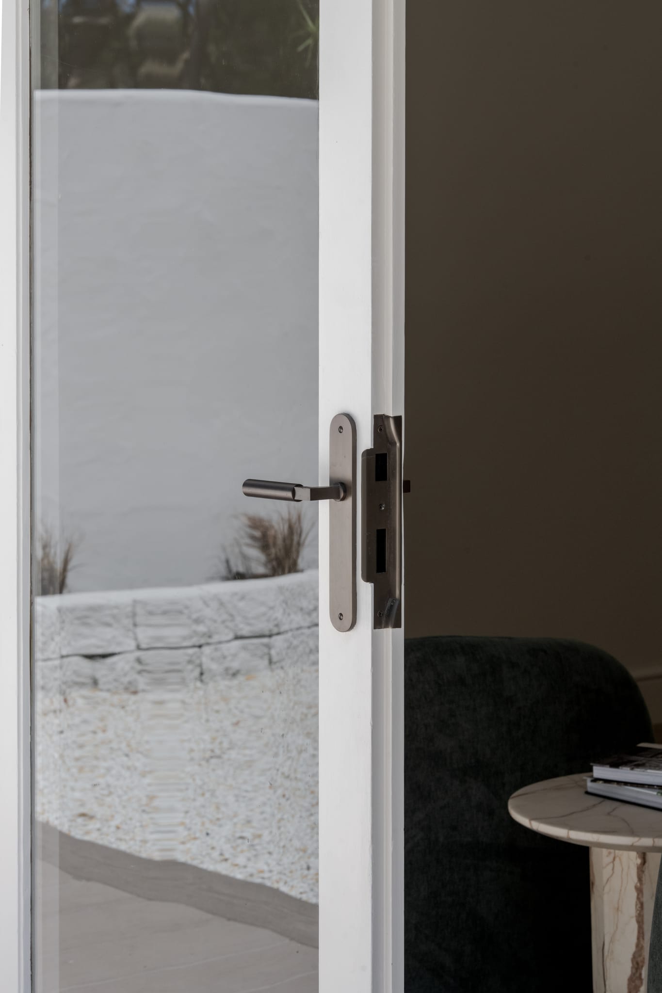 The door leading to the backyard features the Berlin Lever on Oval Backplate in Signature Brass.