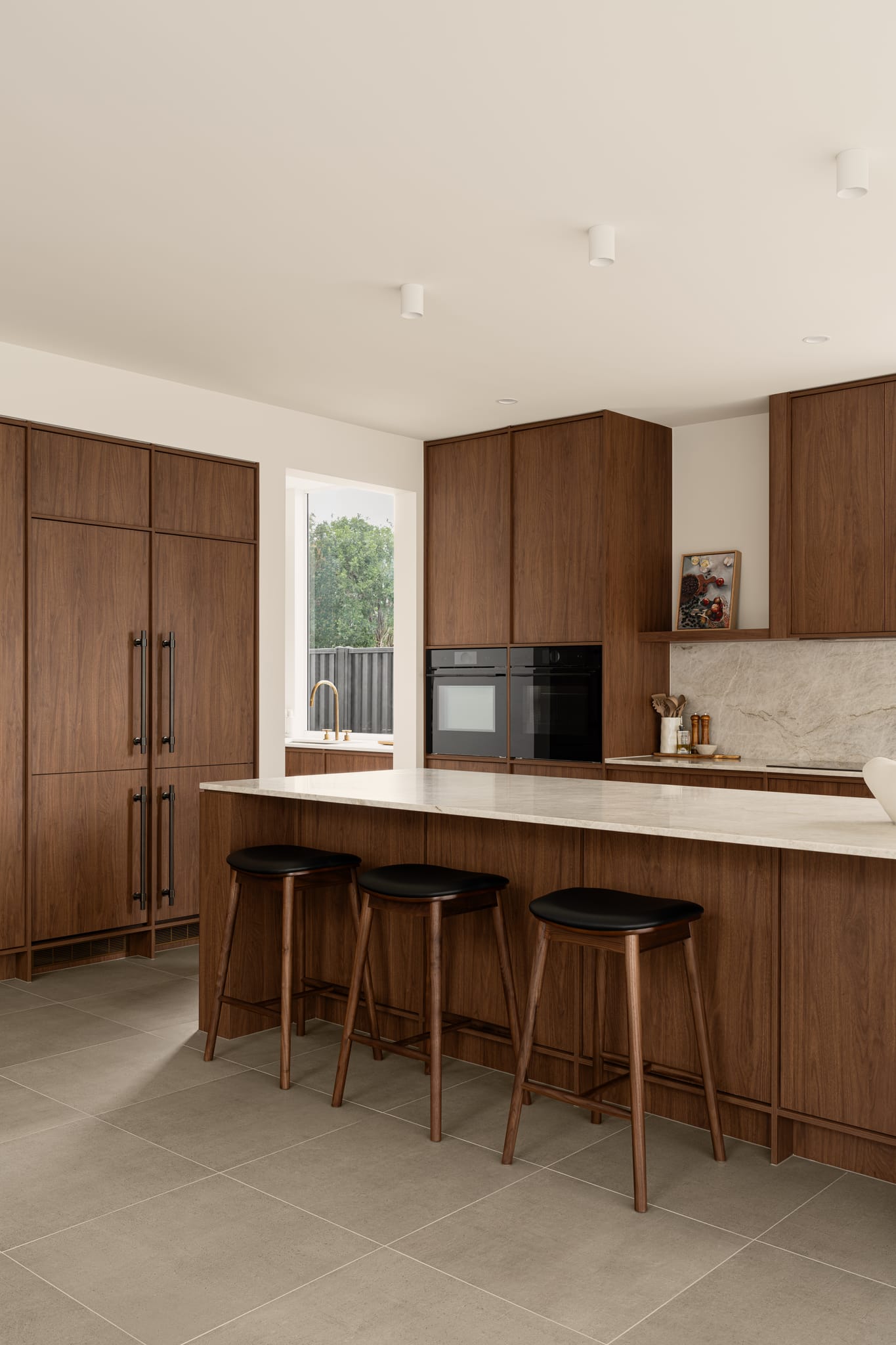 This kitchen features grey tile and dark oak cabinetry. Iver's Helsinki Pull Handles in Signature Brass adorn the kitchen cupboards.